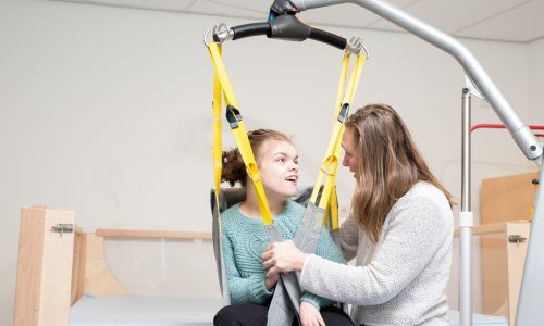 A girl with disability working with a physiotherapist.