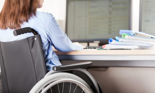 Photo of a woman in a wheelchair working at a computer desk