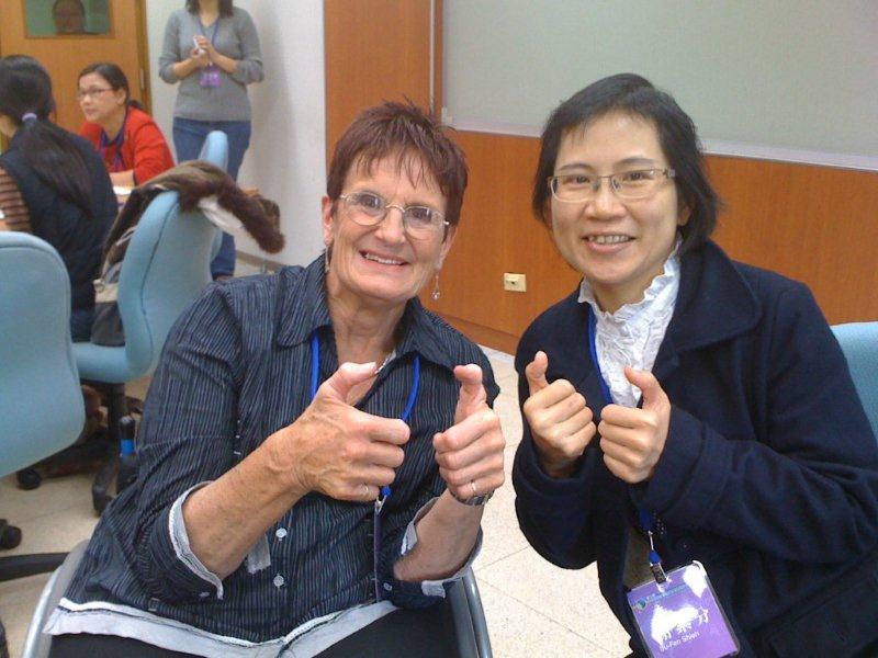 Sue Salthouse with another lady holding up their hands saying thank you in sign language. 