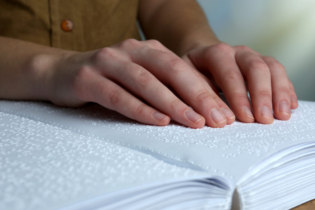 A person reading a book written in Braille