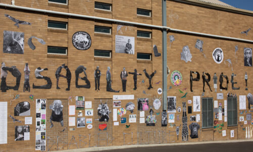An image of the Disability Pride mural in Melbourne. It features many different pasteups on a brick wall, including the text 'Disability Pride' spelt out using images of different disabled people contorting to make the shape of letters.