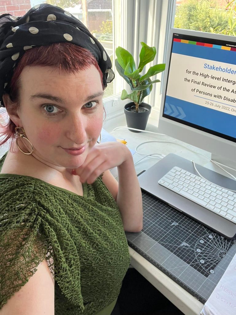 Photo of Saph, wearing a green top and black and white bandana