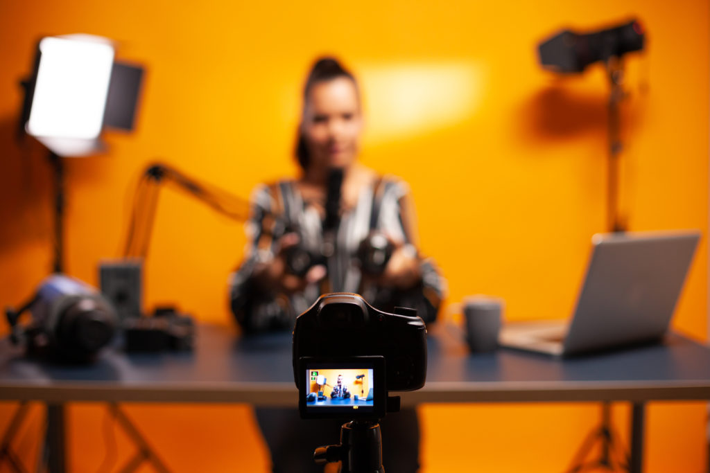 Image: A woman using a professional camera to record a vlog.